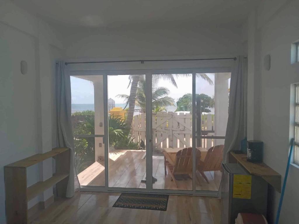a living room with a sliding glass door to a patio at The Novelo in Caye Caulker