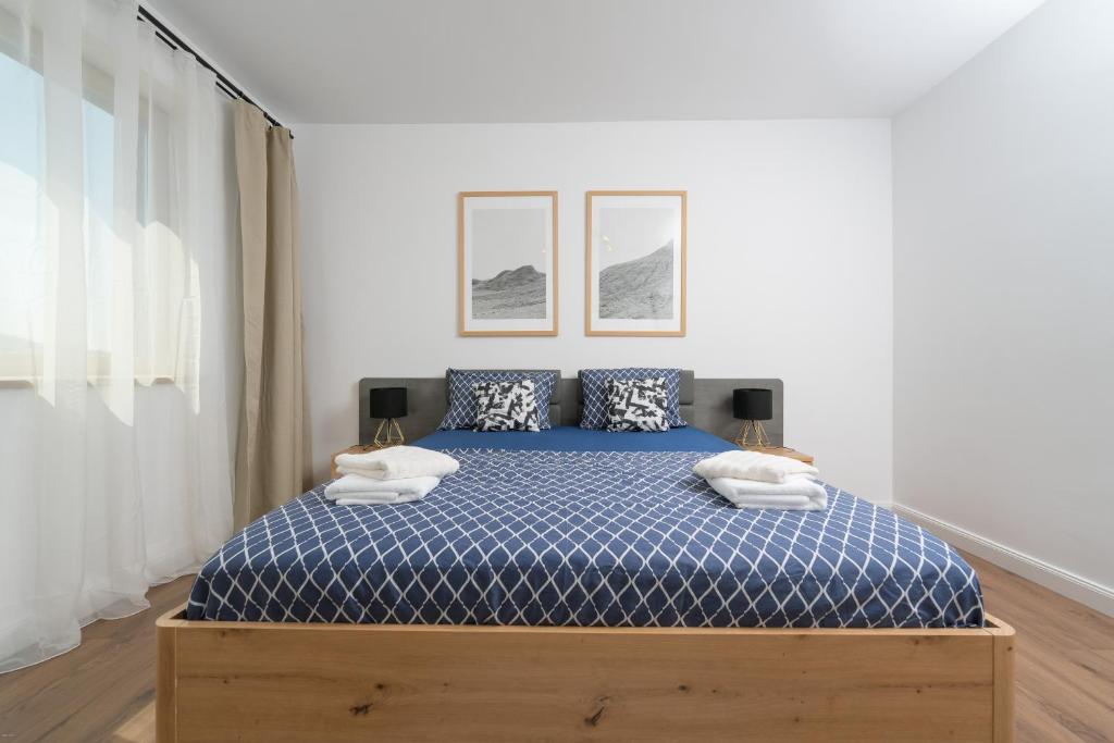 a bedroom with a bed with a blue comforter at The 75 in Târgu-Mureş