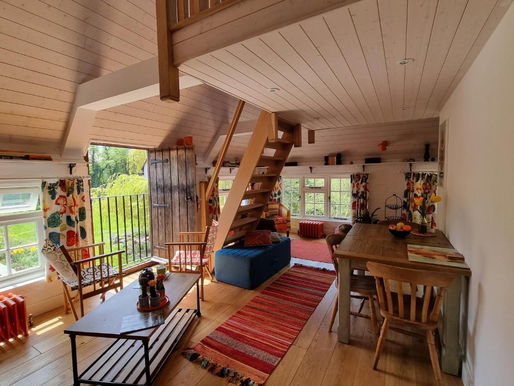 una sala de estar con una escalera de caracol en una casa en Square Oast Studio en West Malling
