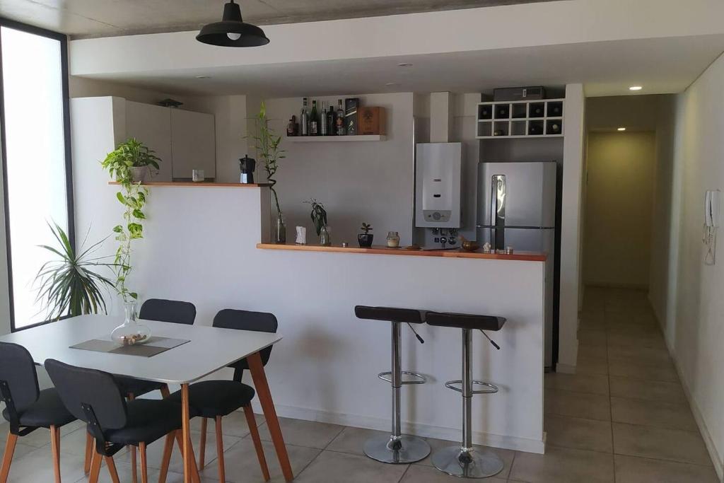 uma cozinha com uma mesa e cadeiras e um frigorífico em Depto 1 dormitorio. Edificio SnJ em Rosário