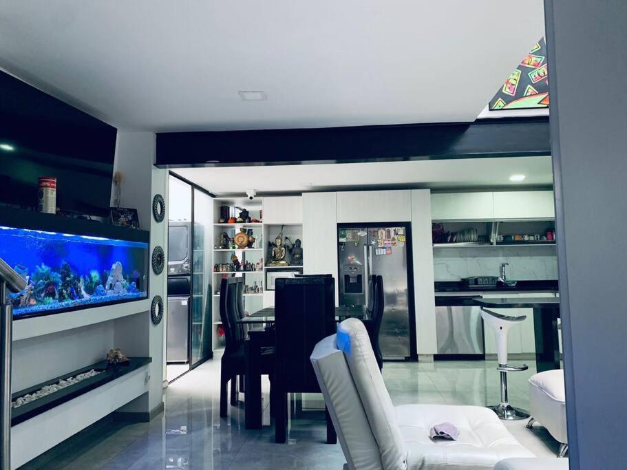 a living room with a fish tank and a table at Espectacular Casa De Lujo in Manizales