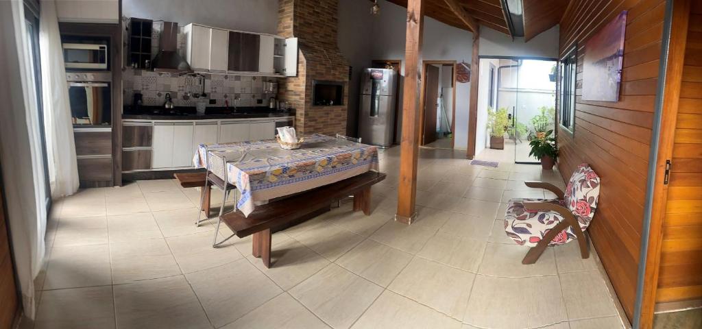 cocina con mesa y nevera en Casa Brisa do Mar: Piscina e Conforto - Penha, en Penha