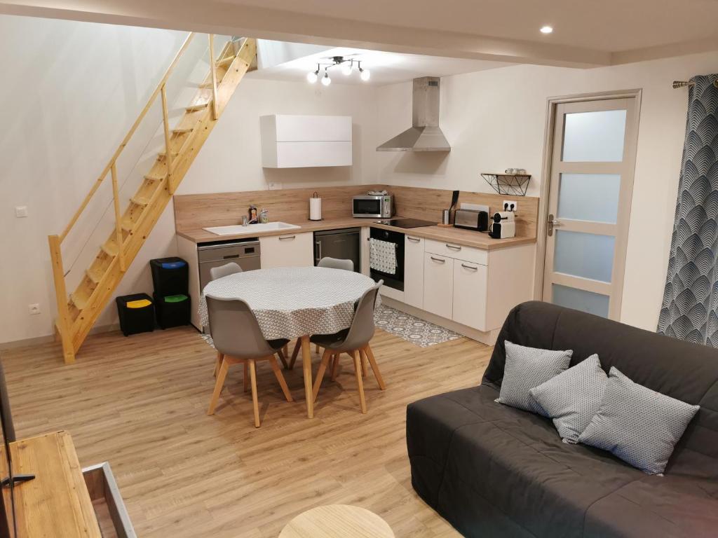 a kitchen and living room with a table and a couch at Studio Climatisé 38m2 Poitiers proche Futuroscope in Buxerolles