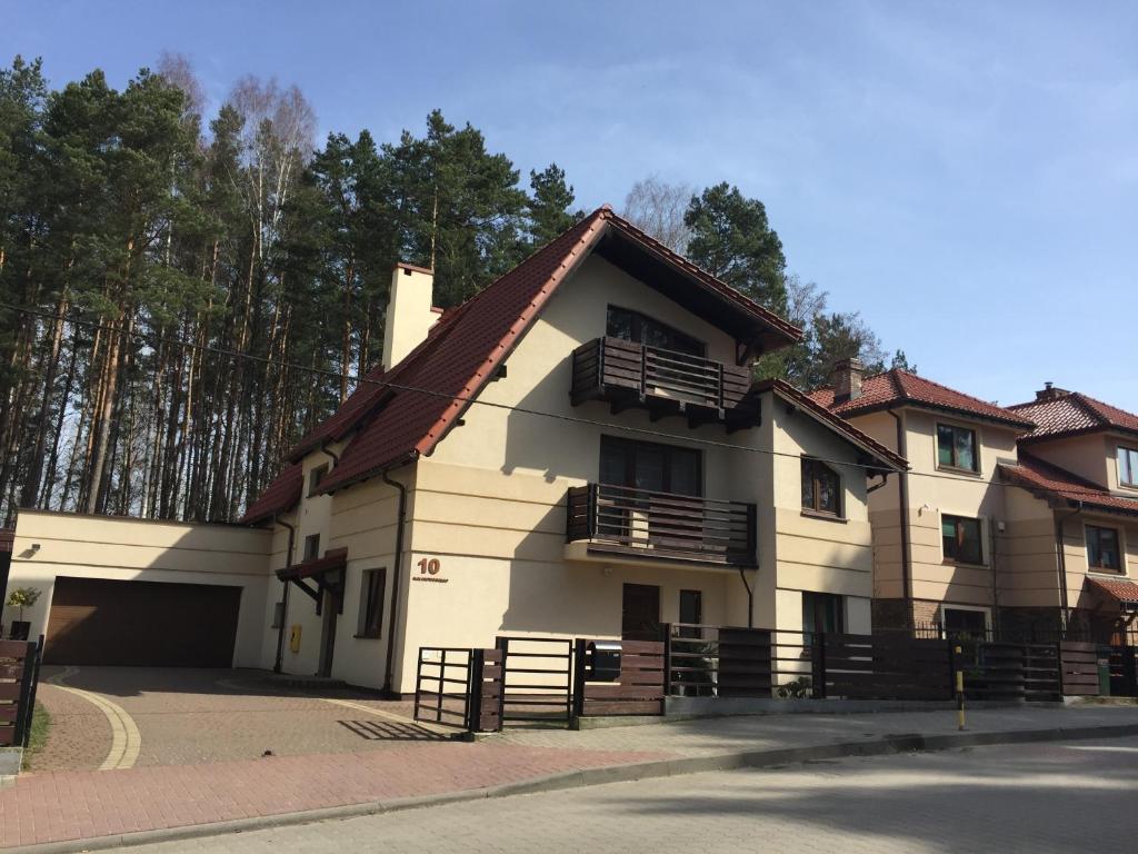 une maison blanche avec un toit marron dans l'établissement InOut Olsztyn, à Olsztyn