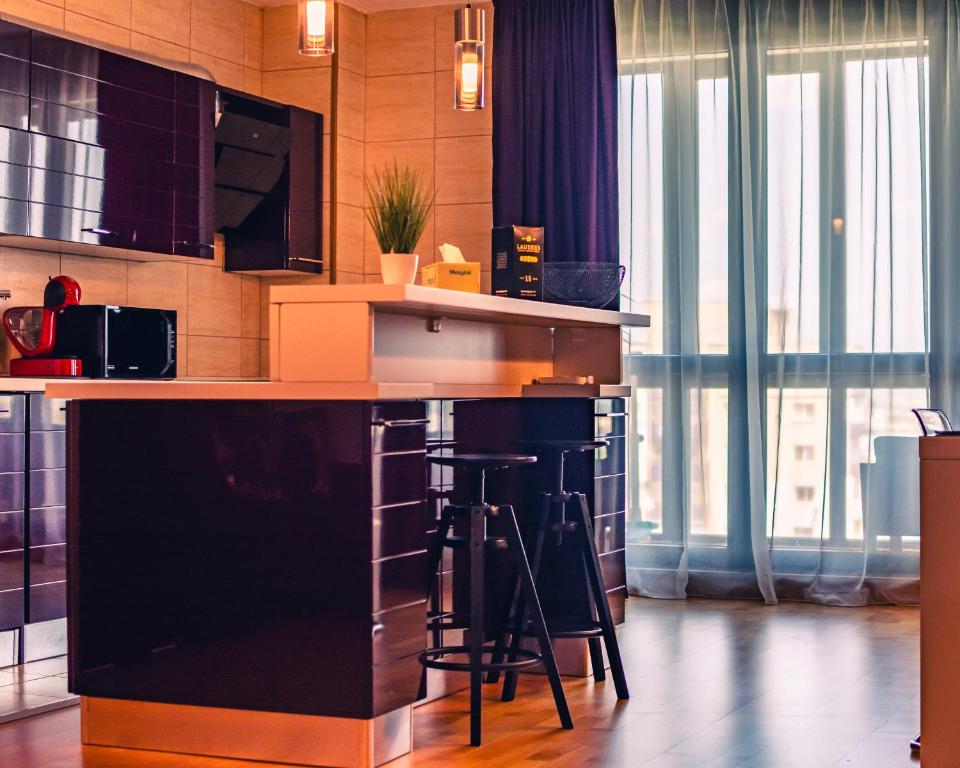 a kitchen with a bar with stools in it at MOZART RESIDENCE PLOIEȘTI Family and Business Apartment in Ploieşti