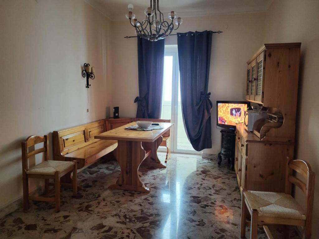 uma sala de jantar com uma mesa e cadeiras e uma janela em Vittoria alata em Bari