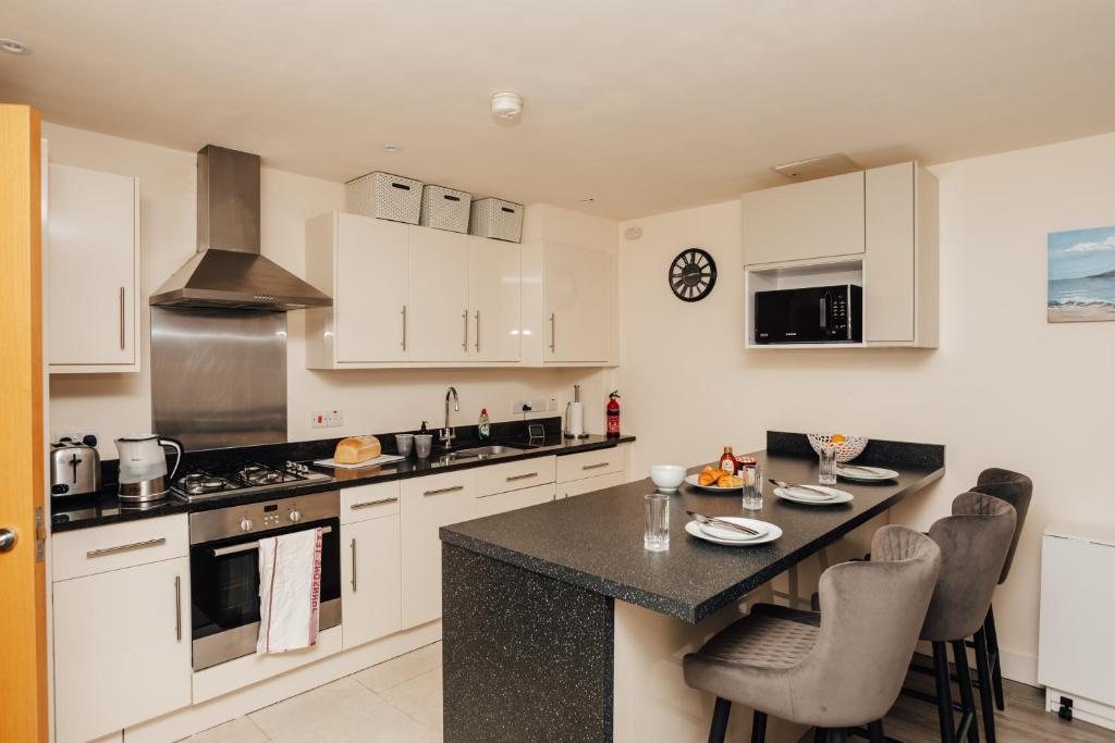 a kitchen with white cabinets and a black counter top at Henley town centre with parking in Henley on Thames