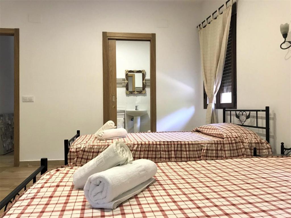 2 camas con toallas en una habitación en La Almazara Del Guijo, en Guijo de Santa Bárbara