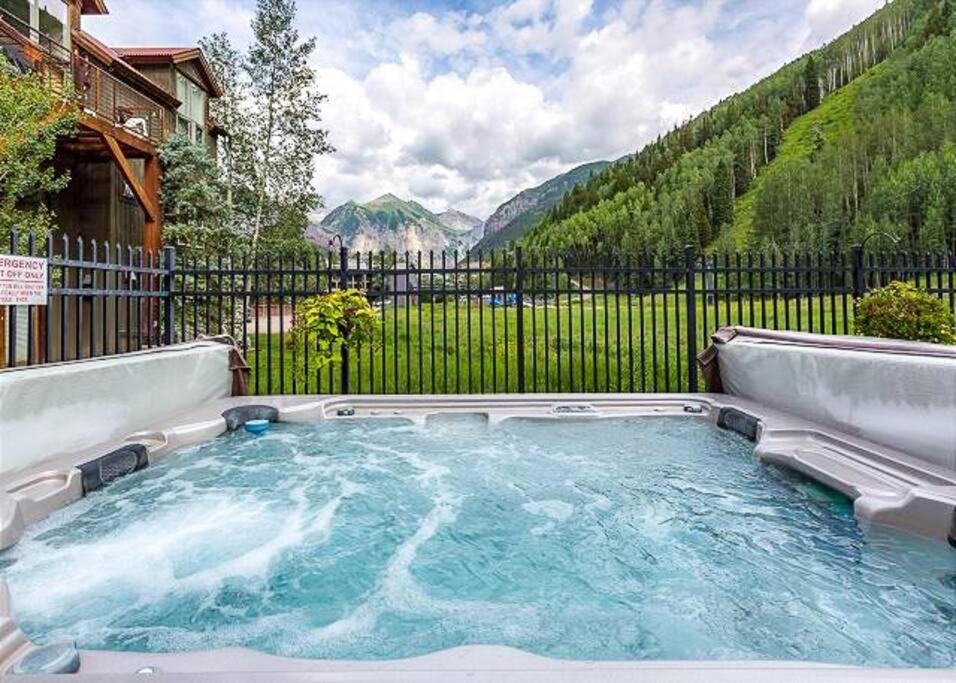 a hot tub in a backyard with a fence at Premier Downtown Telluride Condo with Pool, Hot Tub & Parking in Telluride