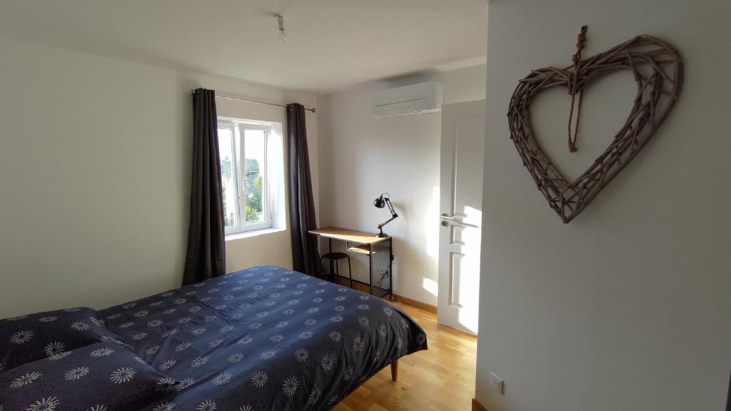 a bedroom with a heart shaped mirror on the wall at Maison 36 in Peyrieu