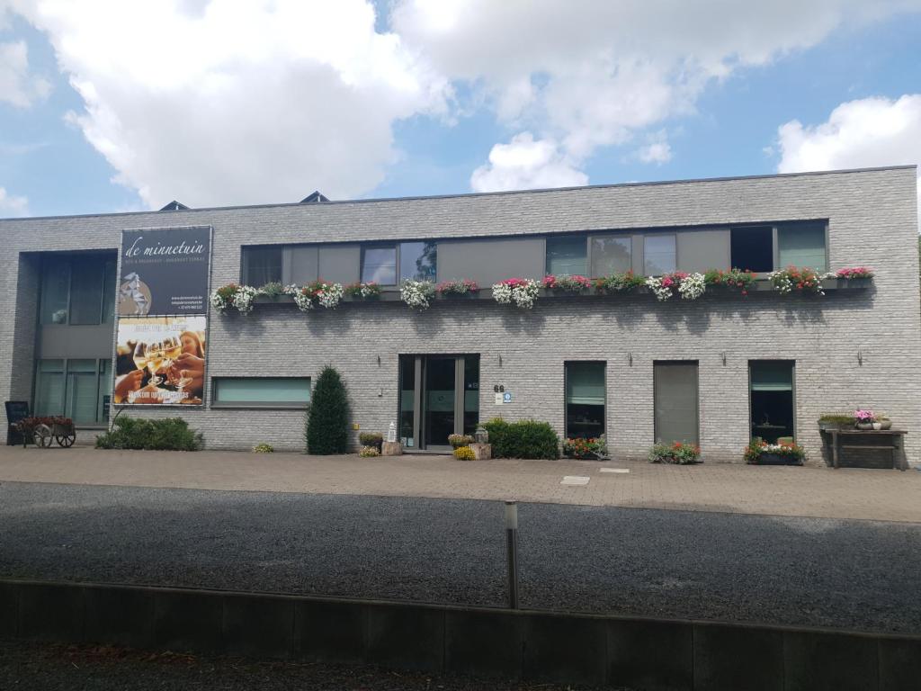 un bâtiment avec des fleurs sur son côté dans l'établissement de minnetuin, à Wachtebeke