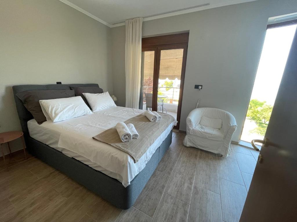 a bedroom with a bed with towels on it at Sunny Seaside Villa-90 m from beach in Kriopigi