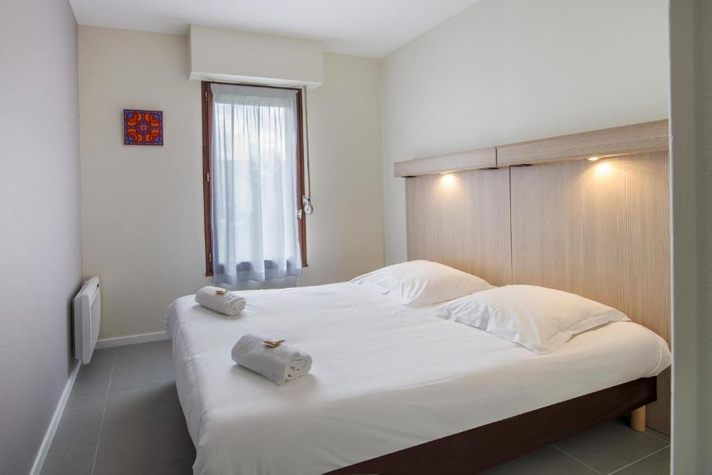 a bedroom with a large white bed with towels on it at Ternélia Henri IV in Clisson