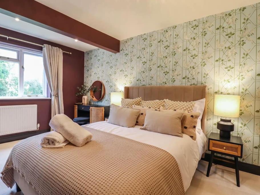 Un dormitorio con una cama grande y una ventana en Beautiful home with hot tub near Cambridge en Royston