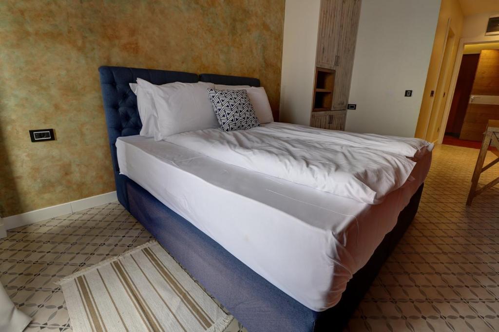 a large bed with a blue headboard in a room at Vlasinsko jezero VILA BEST in Surdulica