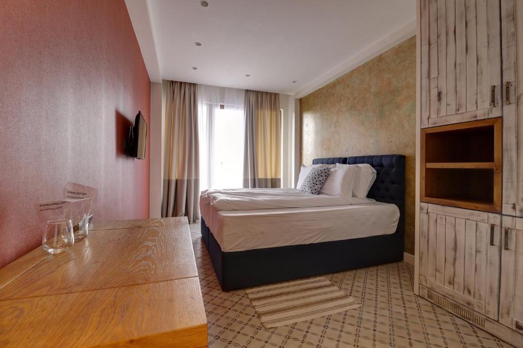 a hotel room with a bed and a table at Vlasinsko jezero VILA BEST in Surdulica