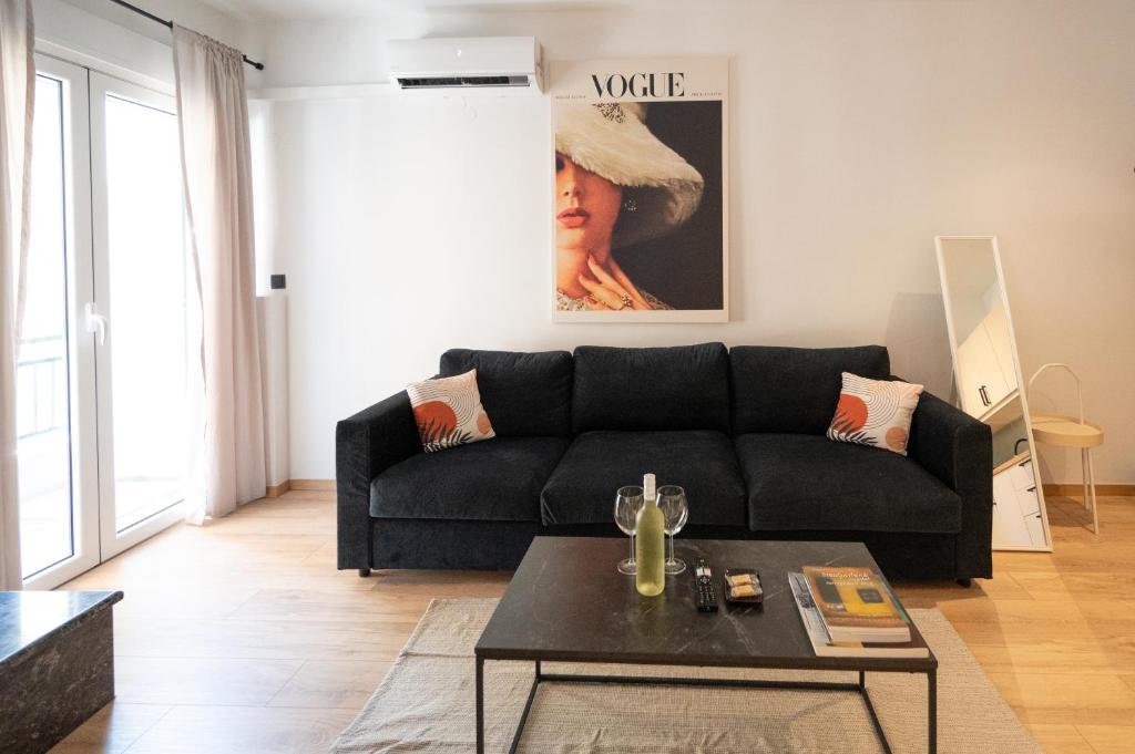 a living room with a black couch and a table at Feelin' Good Apartment in Ioannina