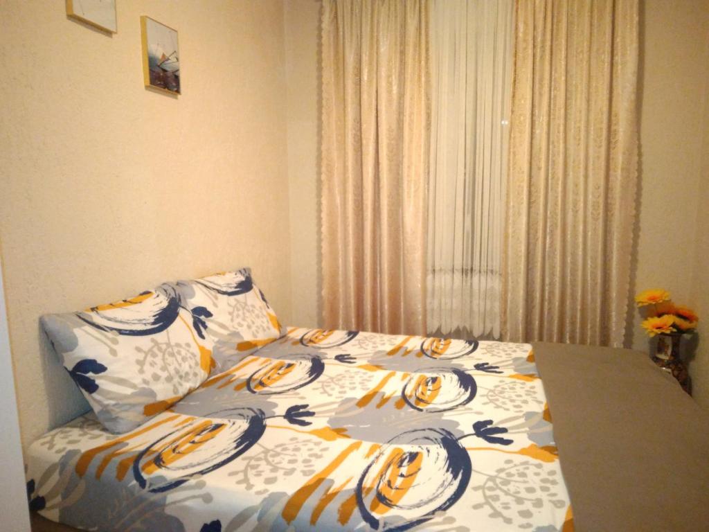 een bed met een dekbed en kussens in een slaapkamer bij TA&TI in Ohrid