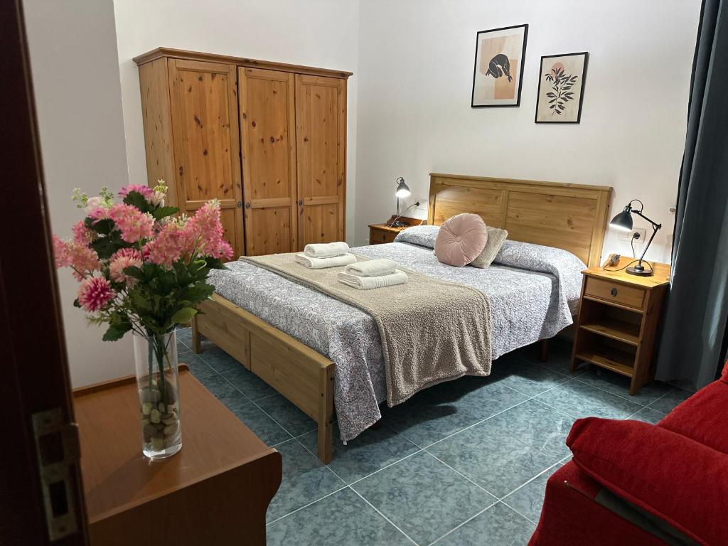 - une chambre avec un lit et un vase de fleurs dans l'établissement Piso ceferino, à Barreiros