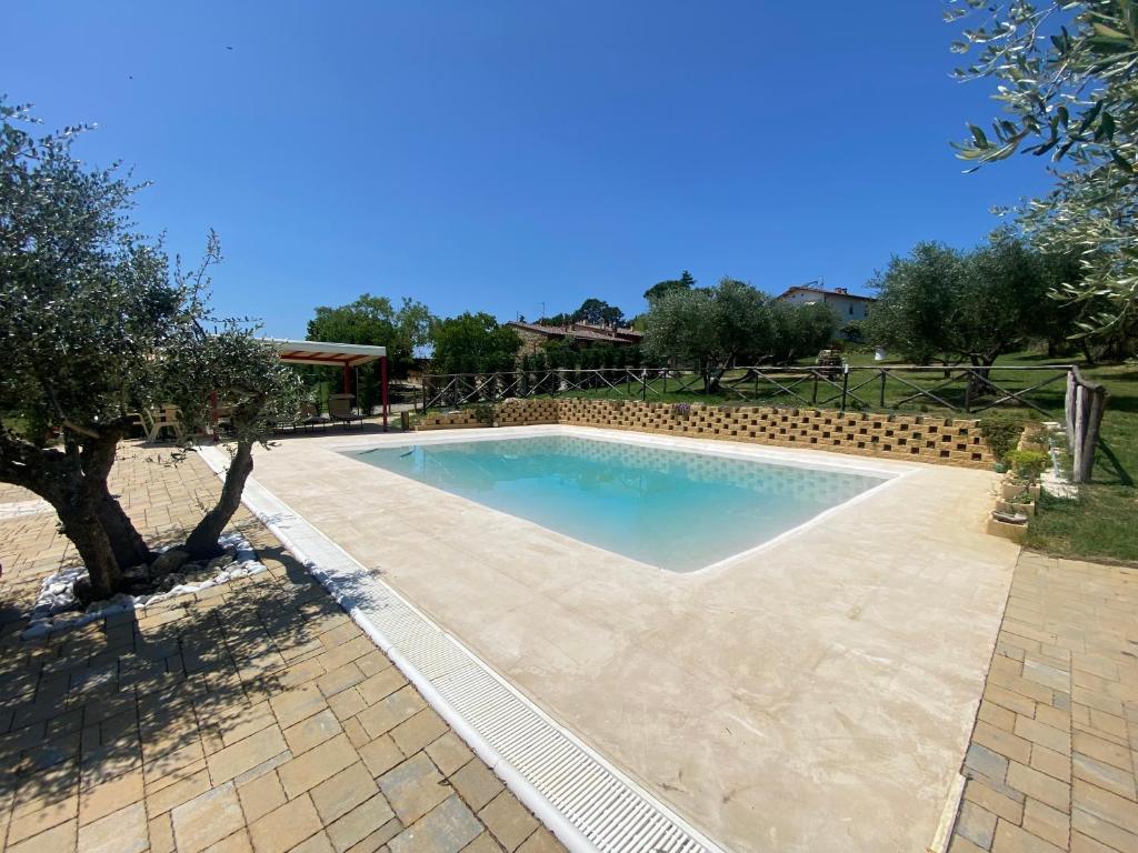 una piscina en un patio con un árbol en Agriturismo privato "La Casa Del Sole", en Castiglione del Lago