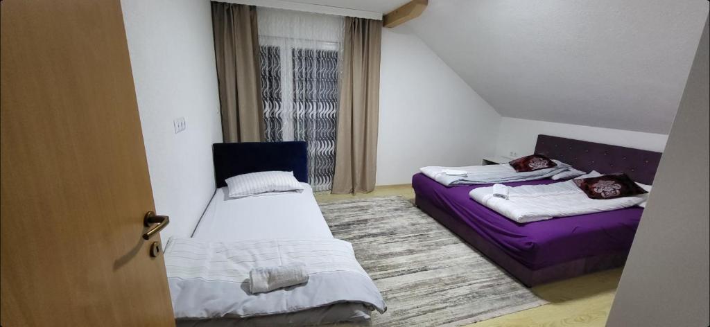 a room with two beds and a purple couch at Apartments Amina Sarajevo in Sarajevo