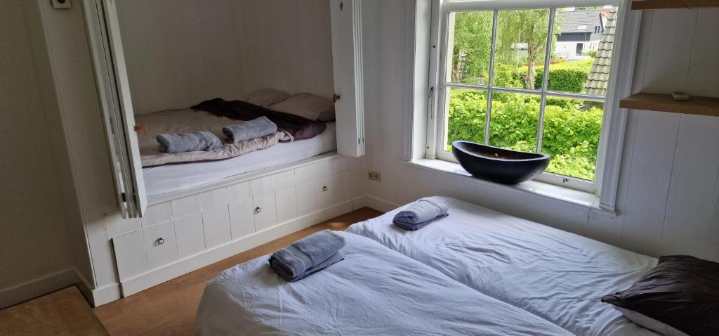 a bedroom with a bed and a mirror and a window at Amsterdam Mansion - Rembrandt in Oostzaan