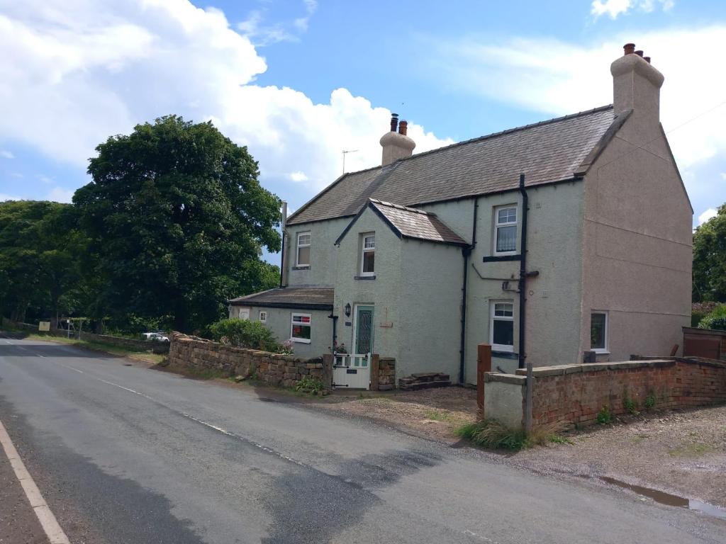 una casa vieja al lado de una carretera en Littlebeck en Danby