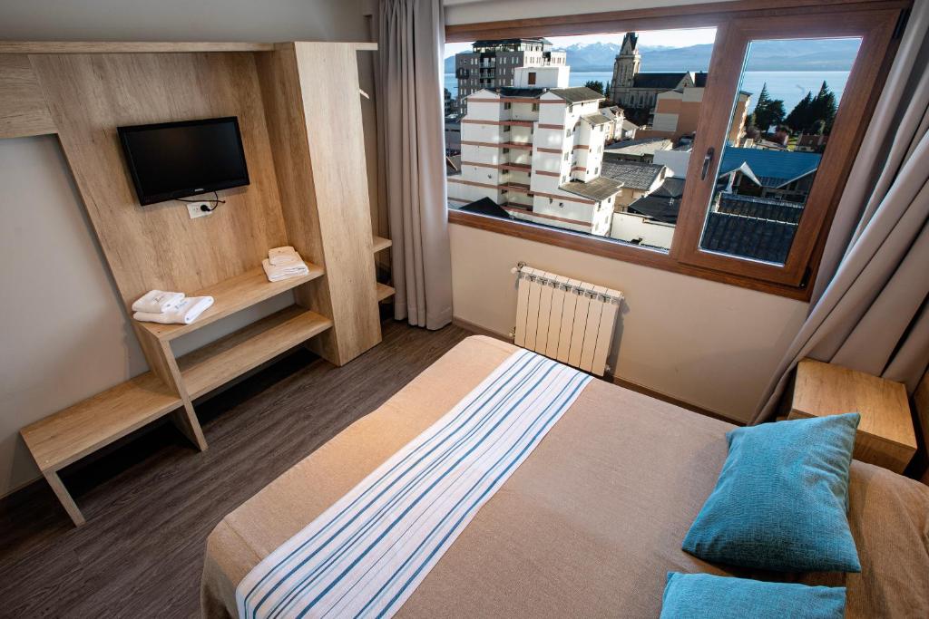 a hotel room with a bed and a window at Hotel 7 Lagos in San Carlos de Bariloche
