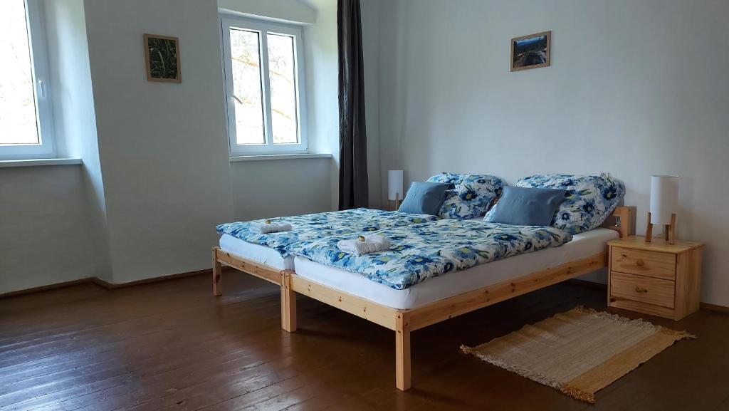 a bedroom with a bed with a blue and white mattress at Chalupa U Kolibříka in Želnava