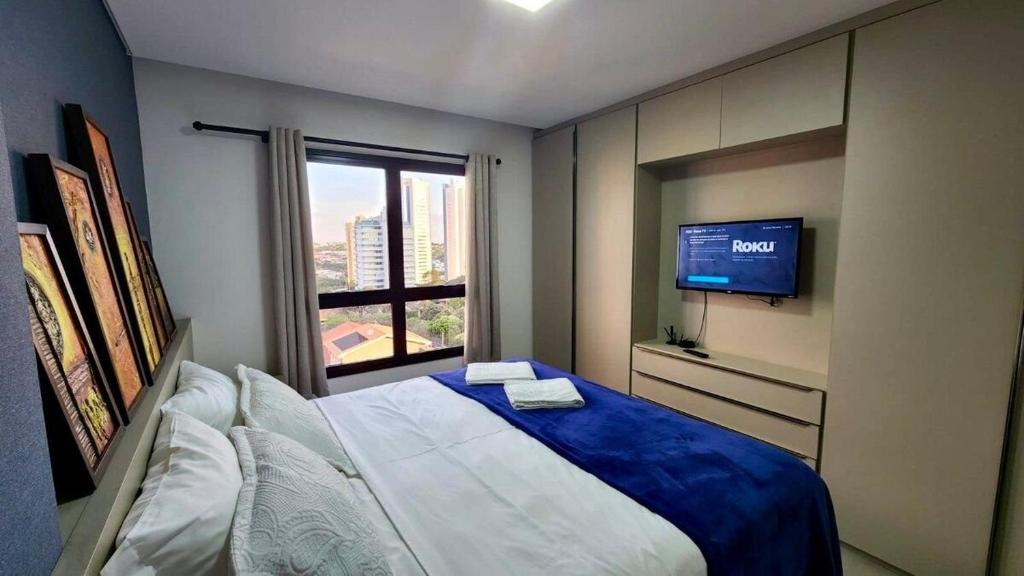 a small bedroom with a bed and a television at Estúdio com Quarto Privativo, TV e Cama Super King in Campo Grande