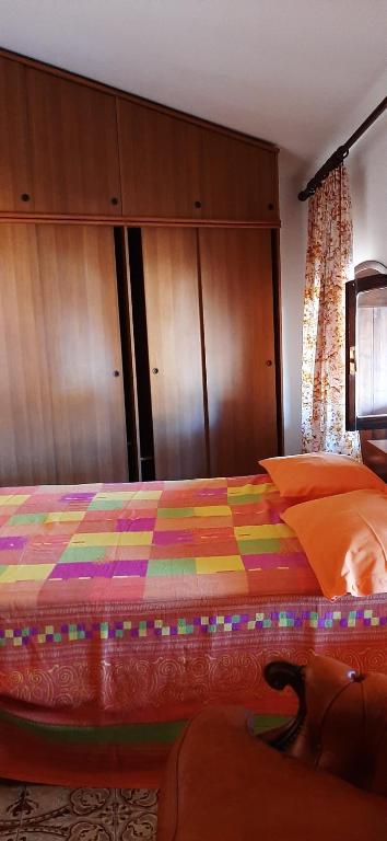 a bedroom with a colorful bed with a cat laying on it at Affitta stanza da Paola INTRA Lago in Intra