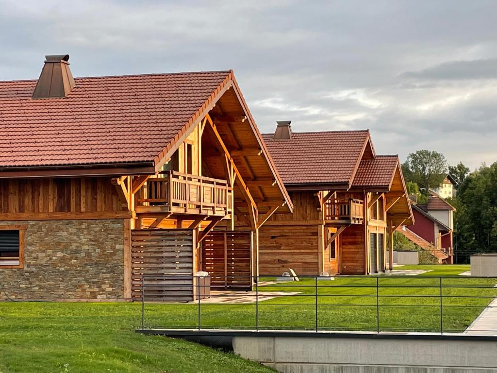 a log home with a deck on the side of it at Chalets Coeur du Lac in Malbuisson