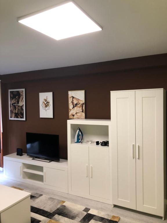 a living room with a white cabinet and a television at Piso Negreira in Negreira