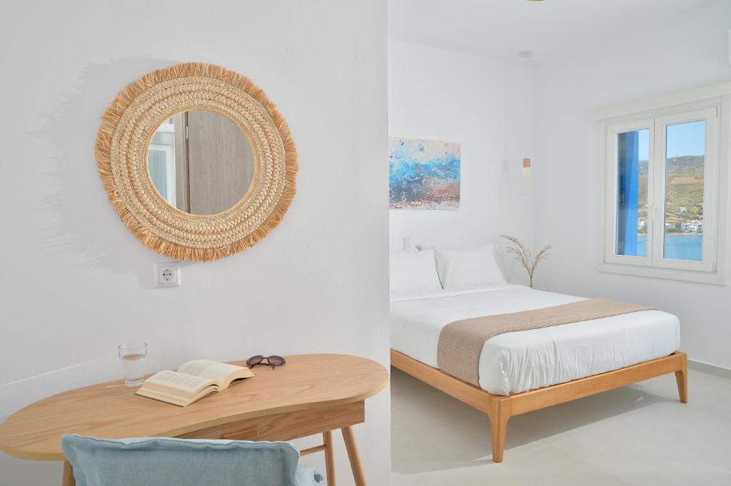 um quarto com uma cama e um espelho na parede em Villa & Studio Hydroussa by Andros Homes em Gavrion