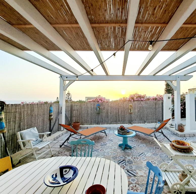 patio ze stołami i krzesłami na tarasie w obiekcie La Villa di Eracle w mieście Licata