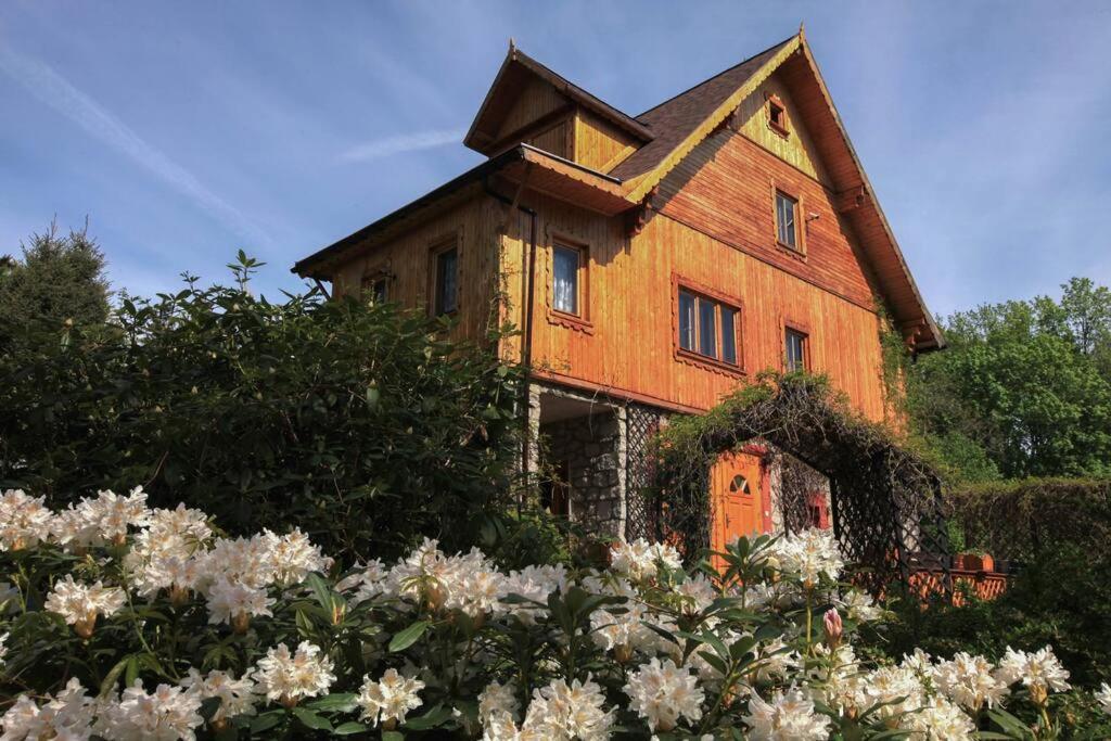 una casa vieja con flores delante en Vakantiehuis Reuzengebergte, en Szklarska Poręba