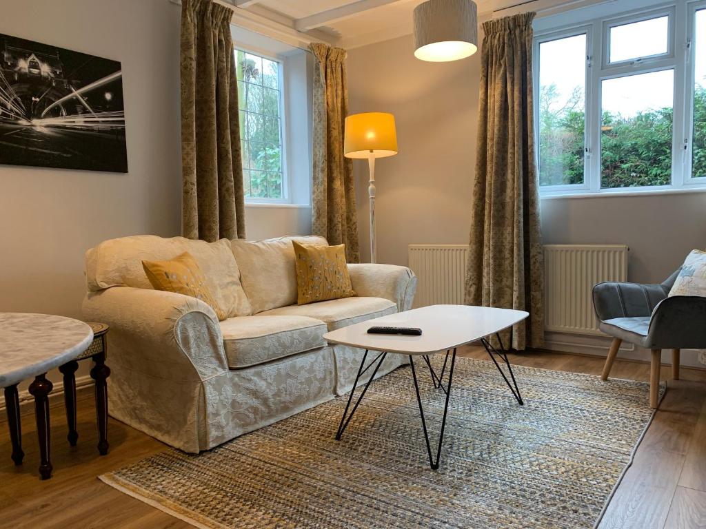 uma sala de estar com um sofá e uma mesa em Peaceful Norfolk Broads 1 Bedroom 2 bath annexe em Halvergate