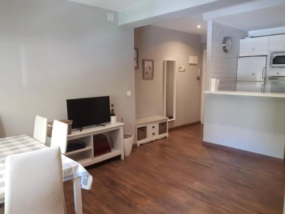 ein Wohnzimmer mit einem TV und einer Küche in der Unterkunft Apartamento en Cádiz playa Victoria in Cádiz