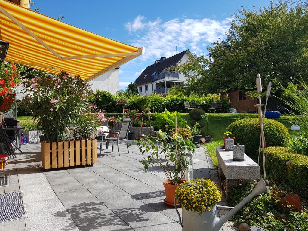 eine Terrasse mit einem Haufen Pflanzen und einem gelben Regenschirm in der Unterkunft Hedasis Ferienwohnung3, 500 m zum Möhnesee in Möhnesee