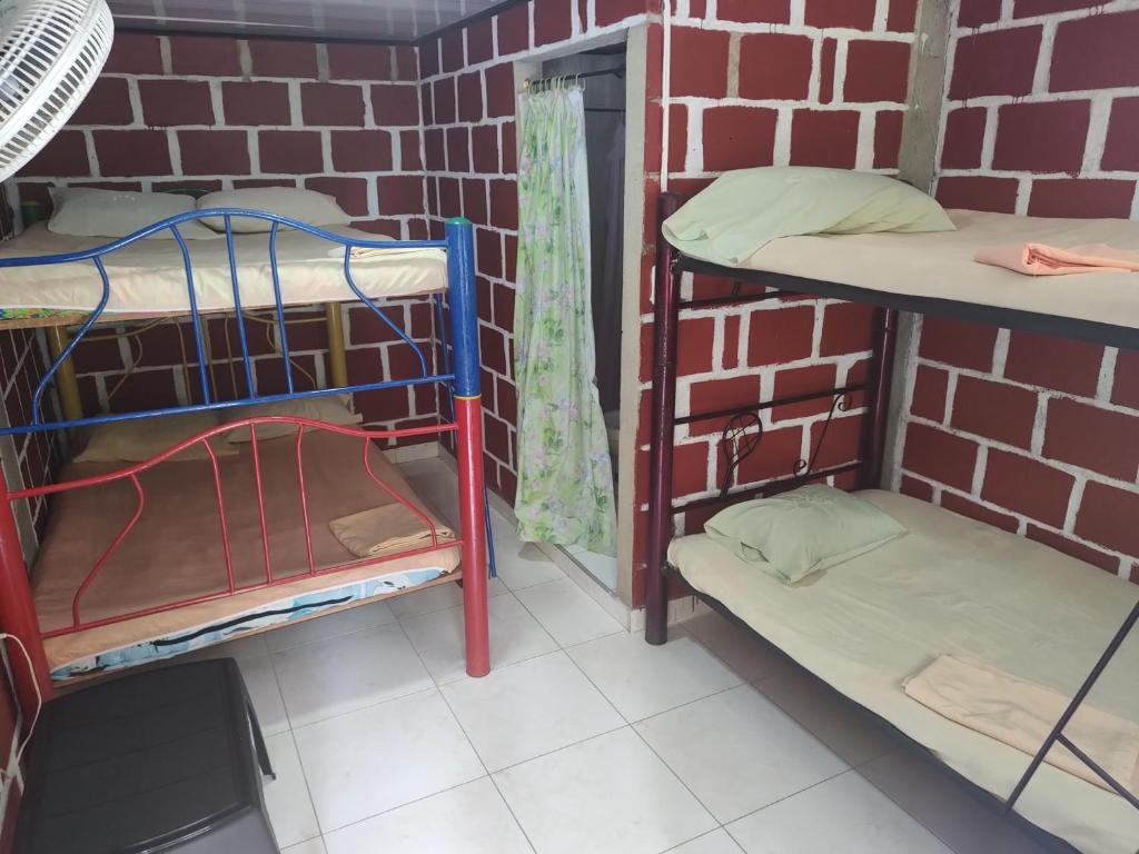 a room with three bunk beds in a brick wall at Casa hospedaje mayesty in San Cipriano