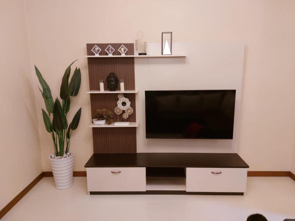 uma sala de estar com uma televisão de ecrã plano na parede em Summersun Residence em Grand Baie