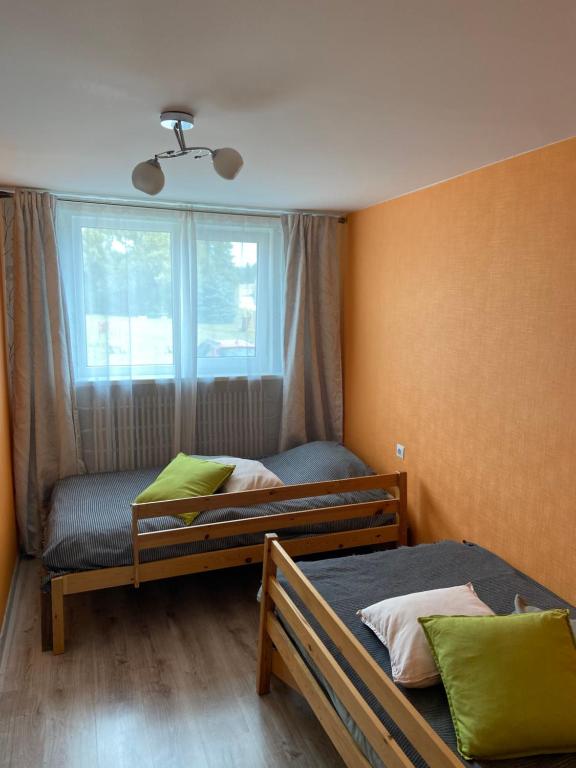 1 dormitorio con 2 camas y ventana en Family stay in Pavilosta en Pāvilosta