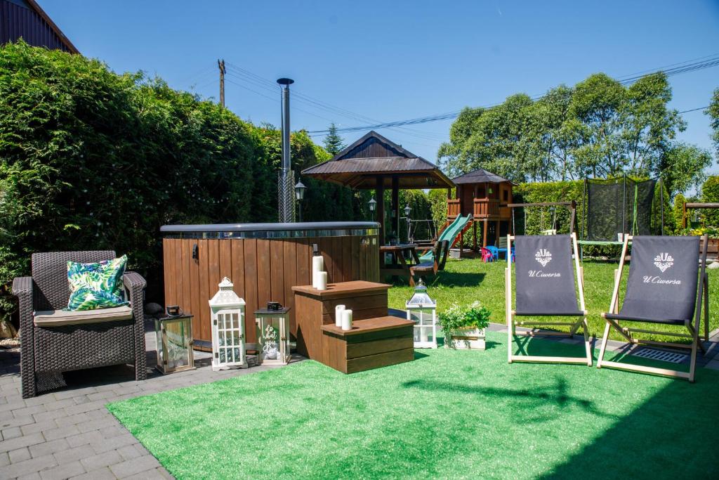 a backyard with two lawn chairs and a playground at Rodzinny Dom Wypoczynkowy u Ciwersa in Białka Tatrzańska