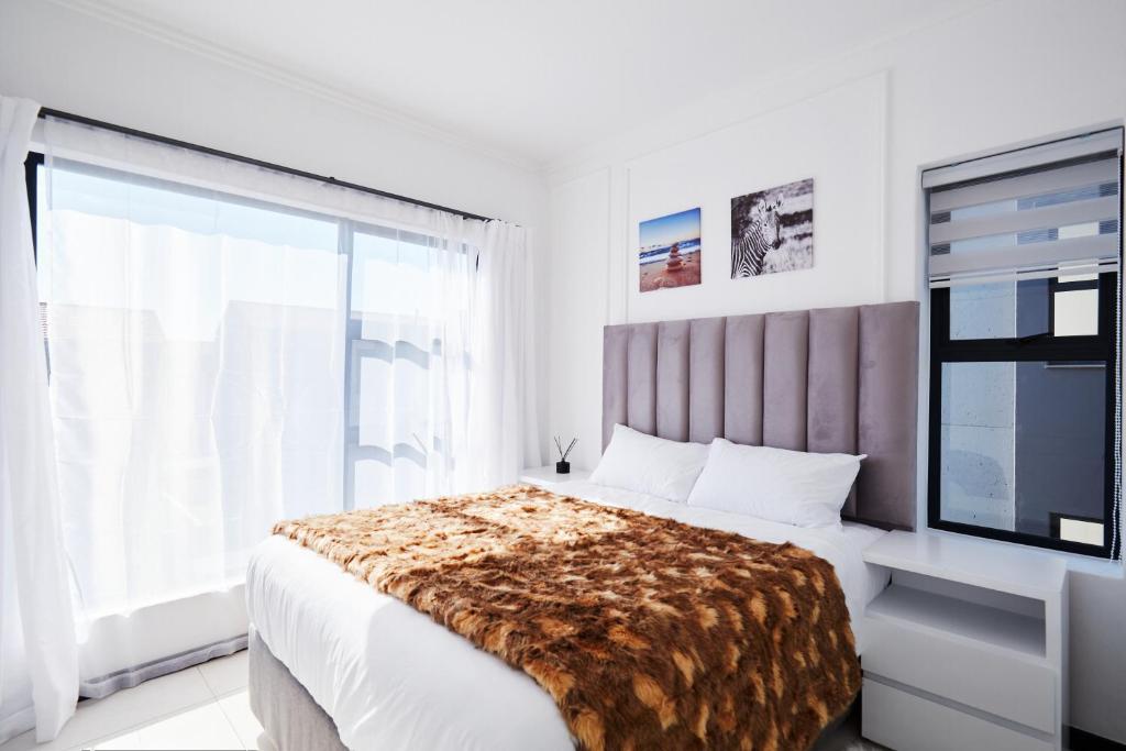 ein Schlafzimmer mit einem Bett und einem großen Fenster in der Unterkunft Luxurious sandton apartment with Inverter in Sandton