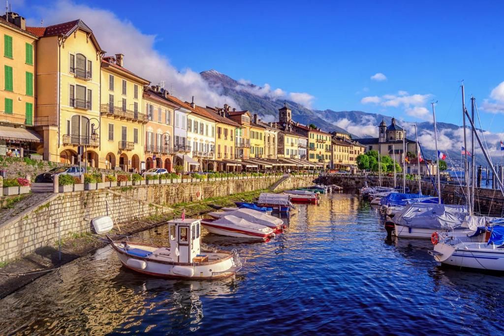 a group of boats docked in a canal with buildings at Residenza Il Gabbiano 3 in Cannobio