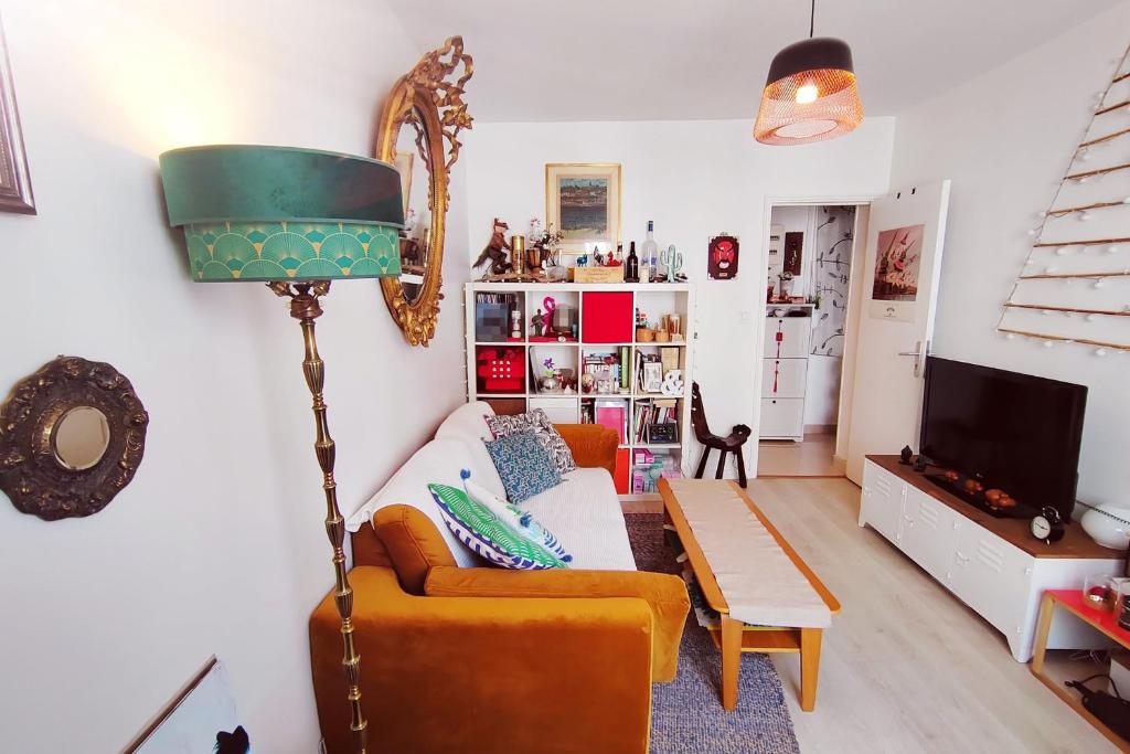 een woonkamer met een bank en een tafel bij Charming 36m2 Apt in Parijs