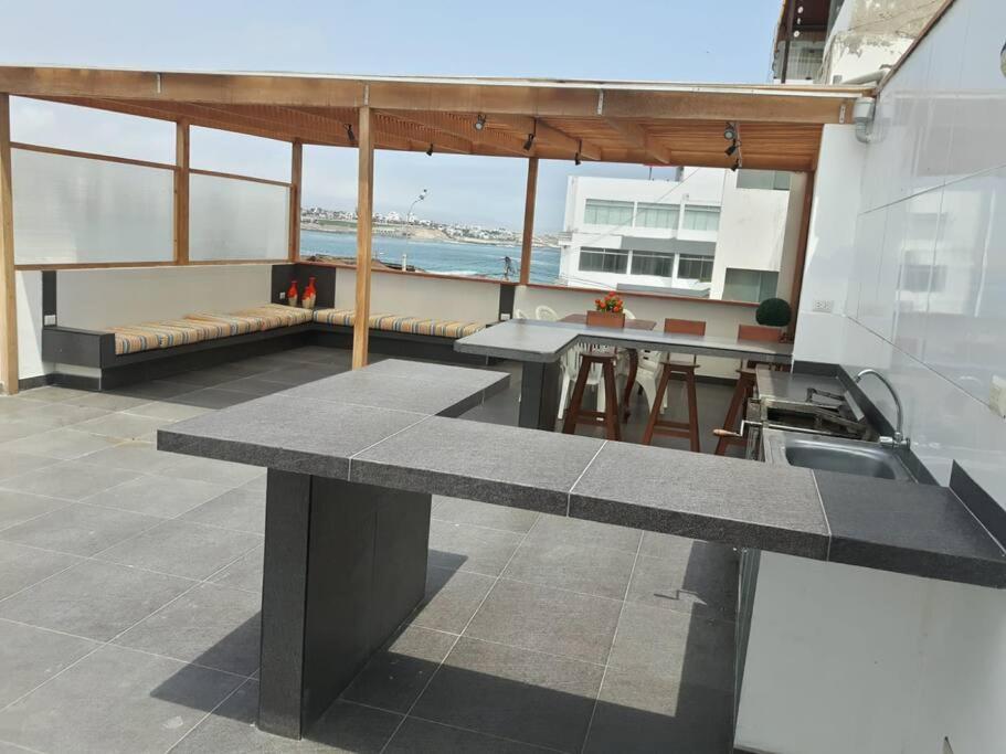 Habitación grande con banco y mesa. en Casa de playa punta hermosa, en Punta Hermosa