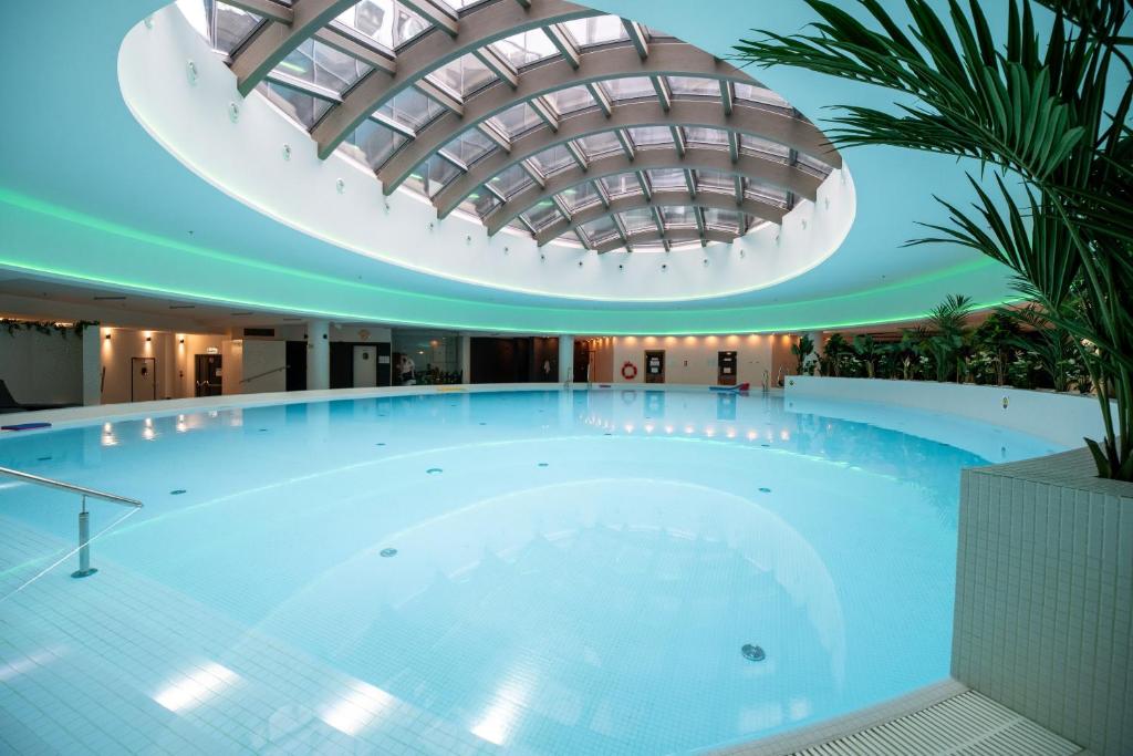 Una gran piscina en un edificio con techo abovedado. en Hanza Tower Luxury, en Szczecin