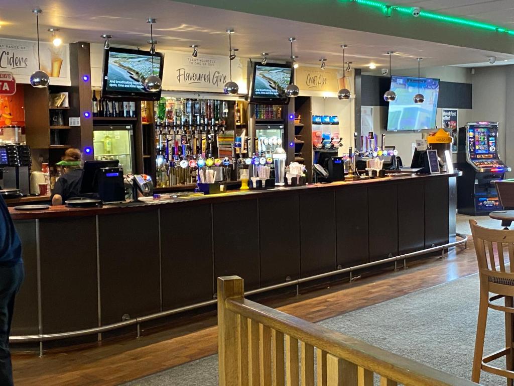 a bar in a pub with a person standing behind it at Comfy Cosy Caravan_Romney Sands in Littlestone-on-Sea