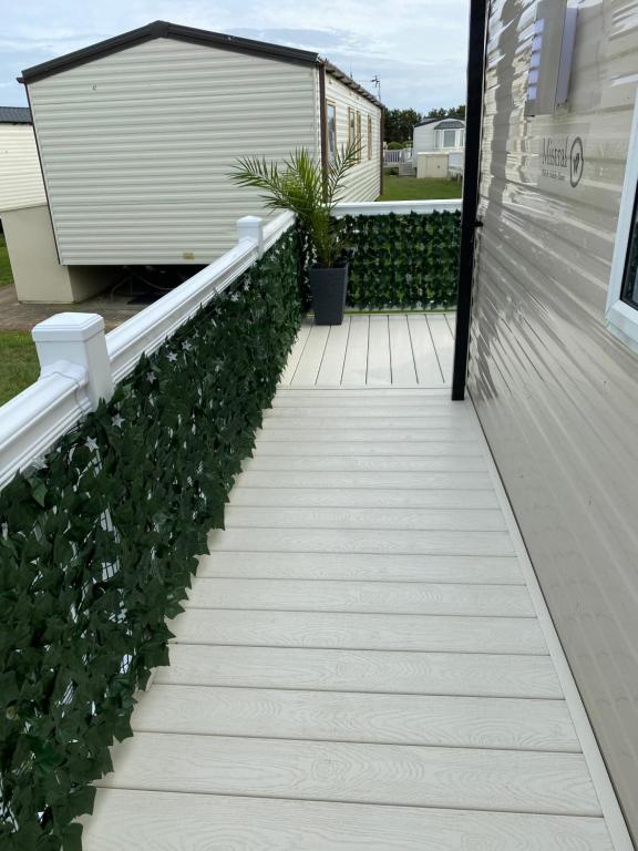 a stairway leading up to a house with plants at Comfy Cosy Caravan_Romney Sands in Littlestone-on-Sea